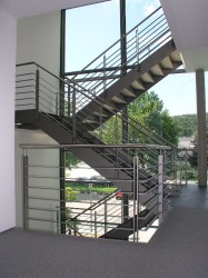Wangentreppe-aus-Stahl-mit-Lochblechstufen-und-Steinbelag